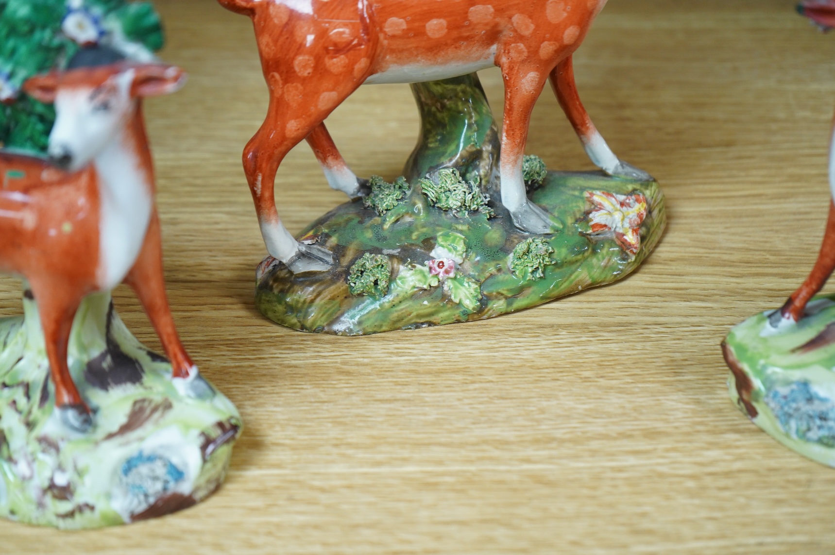 Three early 19th century Staffordshire pottery models of deer, largest 16cm high